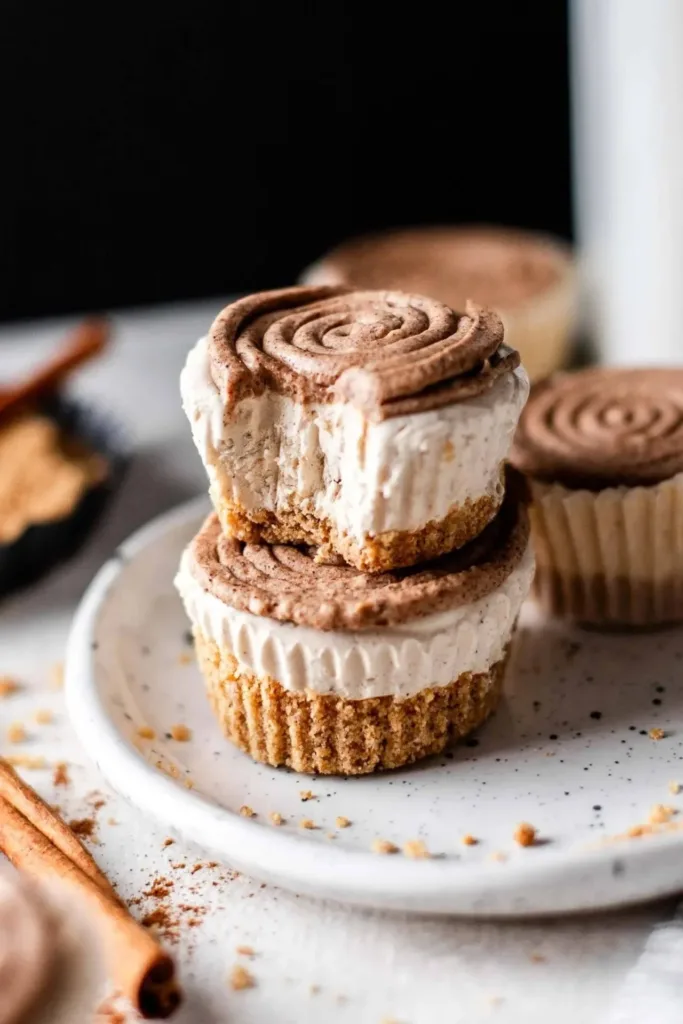 Mini No Bake Cinnamon Roll Cheesecakes topped with swirls of frosting