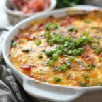 Loaded baked egg casserole topped with cheese and vegetables